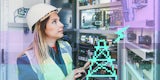 An engineer inspects back-end computers that connect to a power grid.