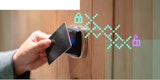 A person uses an RFID card to open a door lock.