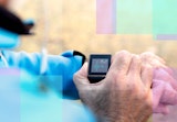 A runner pauses his workout to check his heart rate on his fitness tracker.